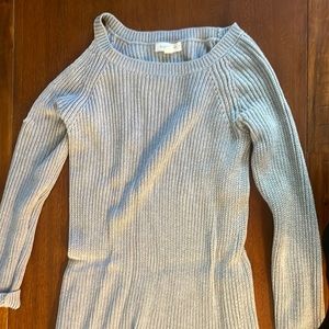 Grey knit sweater with shoulder cutout.